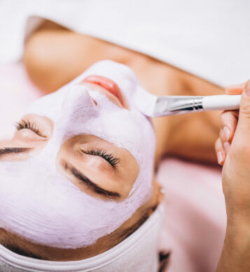 Cosmetologist applying mask on a face of client in a beauty salon